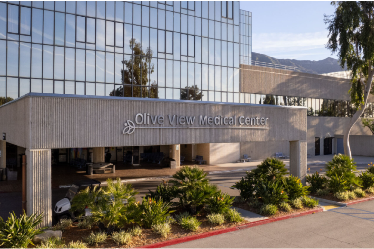 Modern campus building entrance with concrete canopy and glass facade