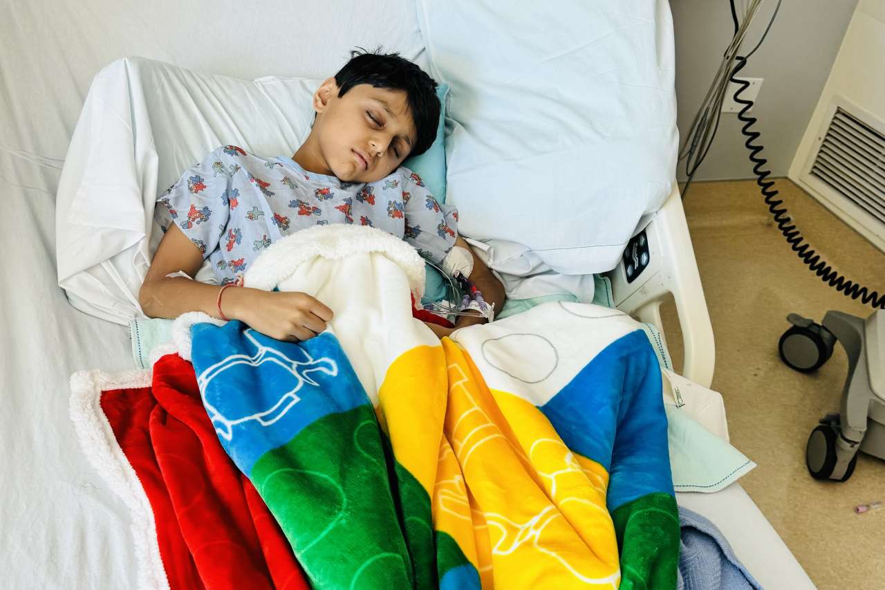 A boy sleeps in a hospital bed.