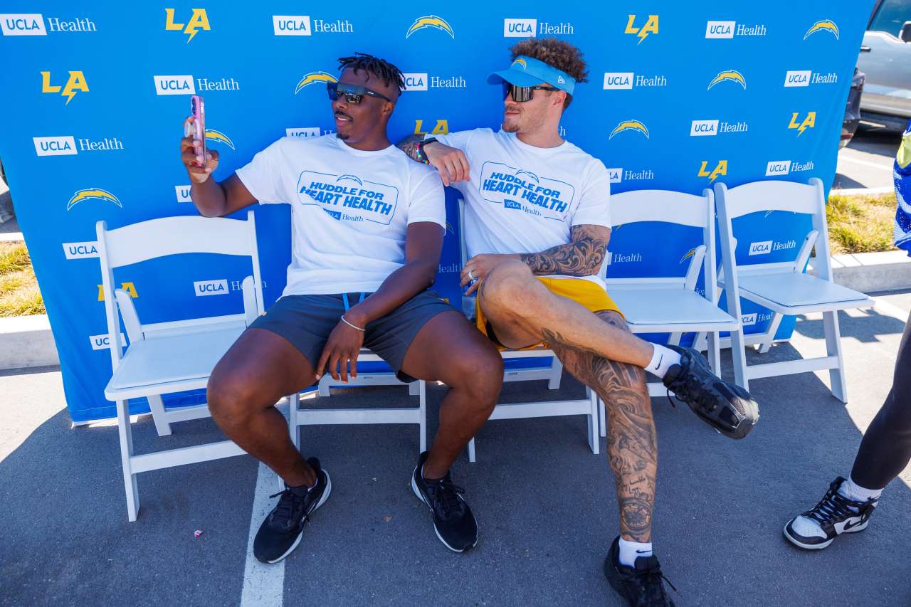 Two LA Chargers players sit during a CPR training event.