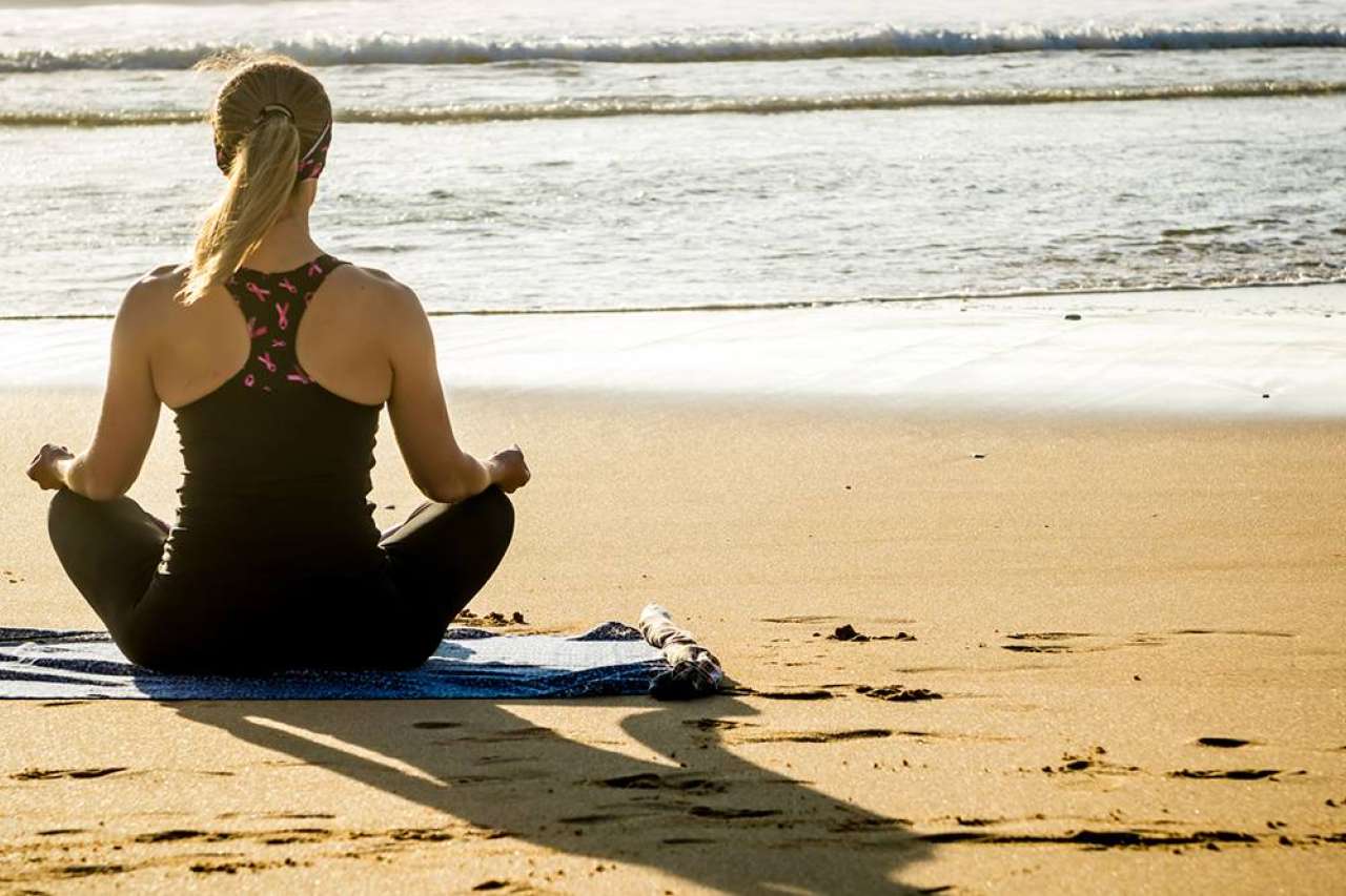Woman meditating on a beach