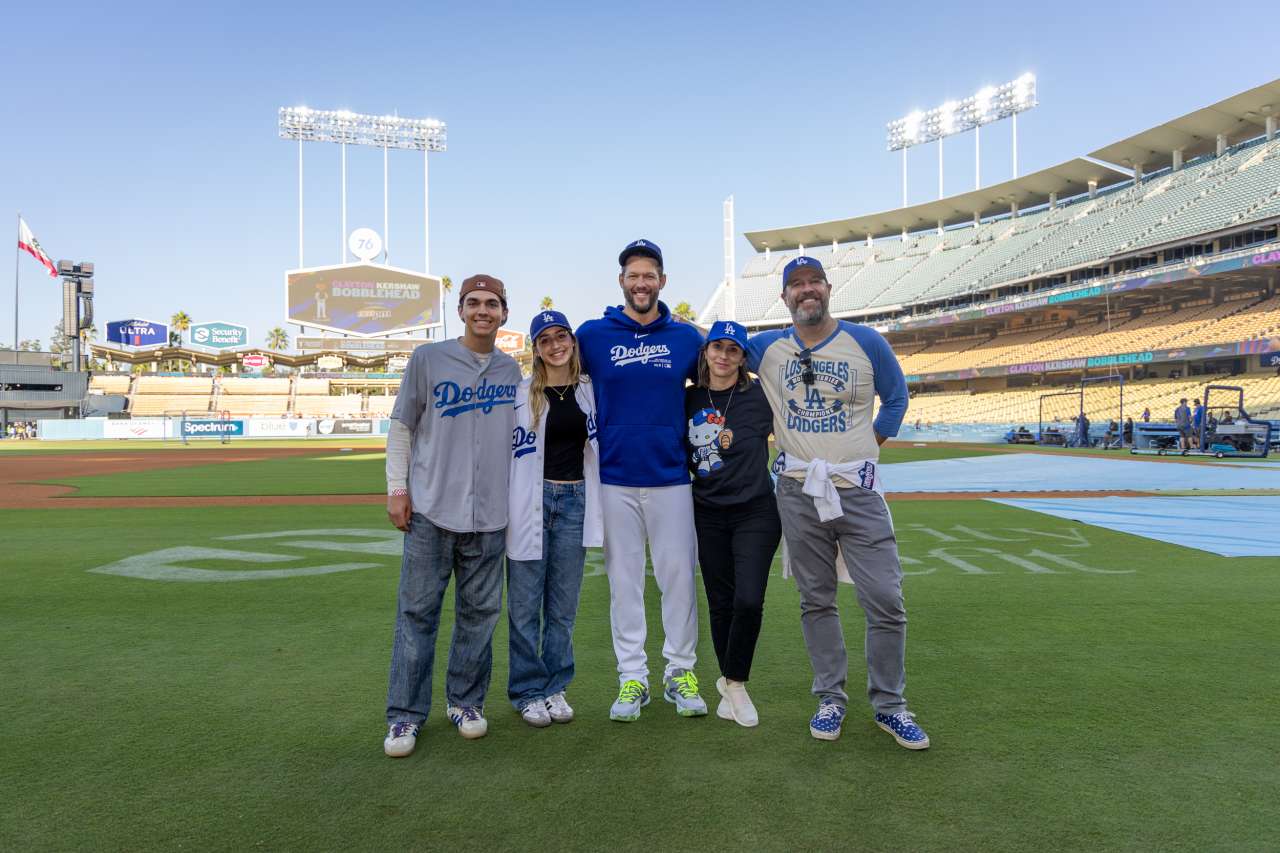 Josie Le Blanc and her family pose for a photo with pitcher Clayton Kershaw on the field at Dodger Stadium