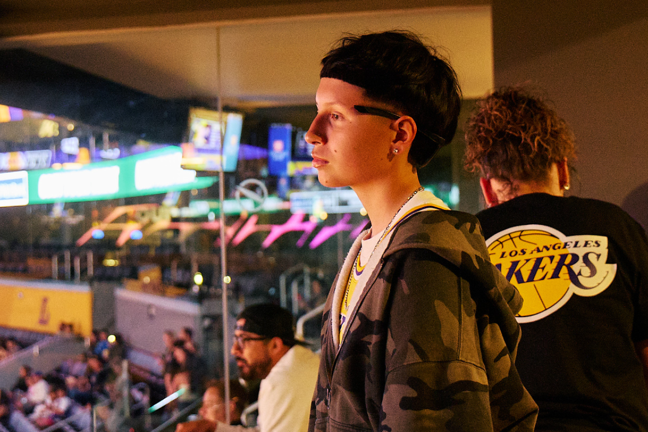 A teen girl looks out to the Lakers court from a suite.