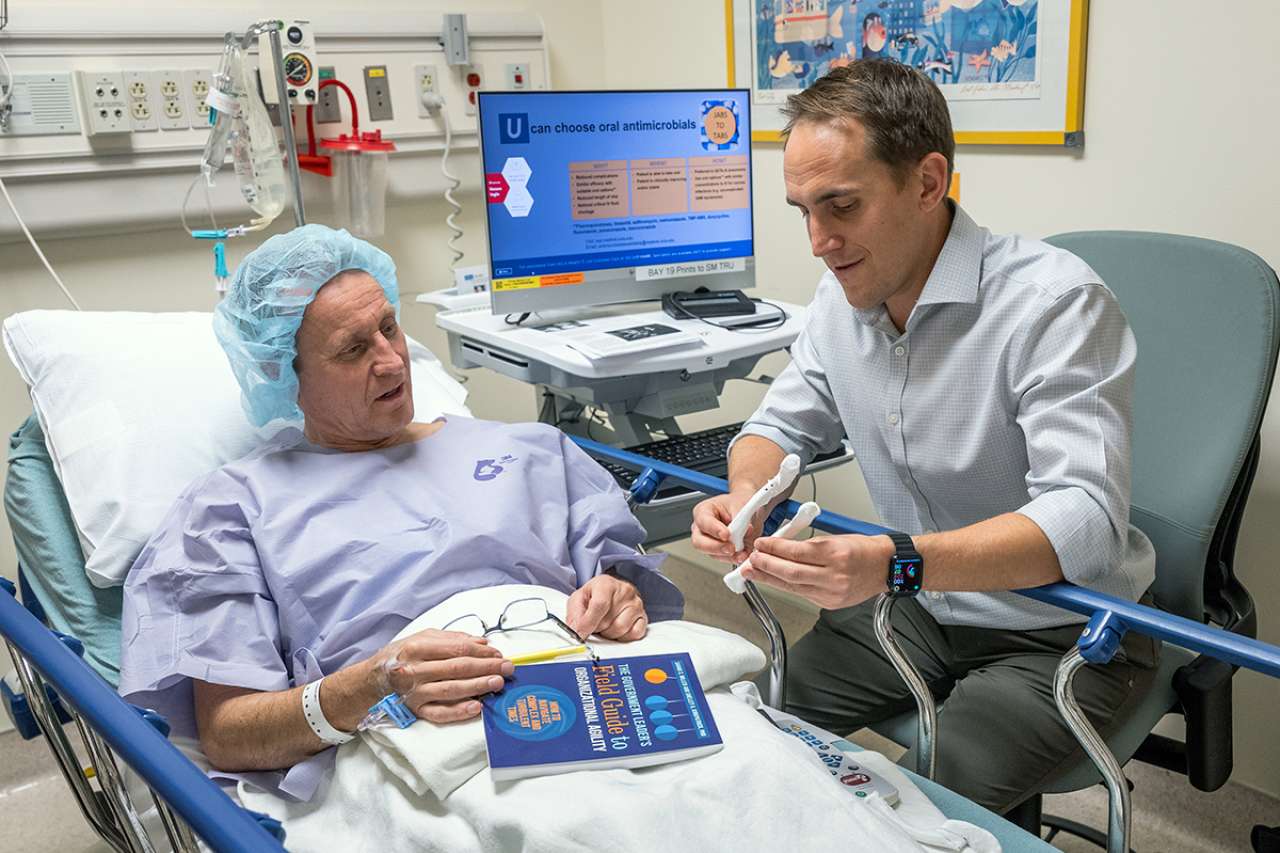 Patient in hospital bed speaking to doctor