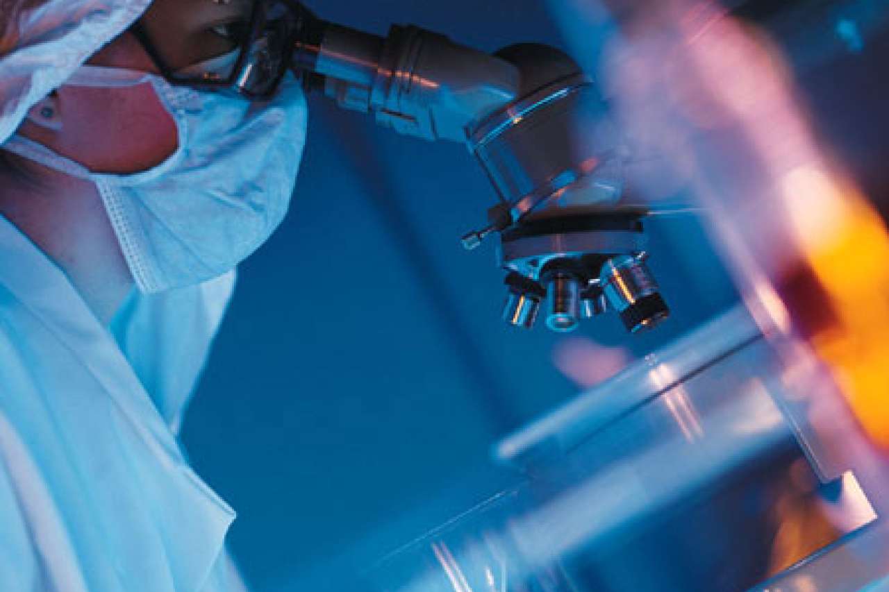 A researcher using a microscope to analyze a sample
