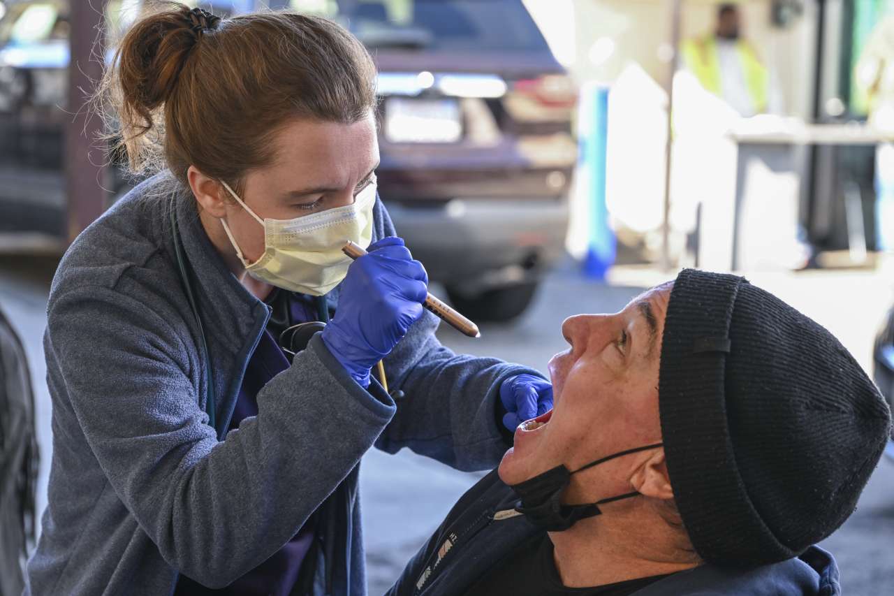 Nurse Kate Gieschen examines the throat of patient Franklin McCutcheon during a shift with the Homeless Healthcare unit.