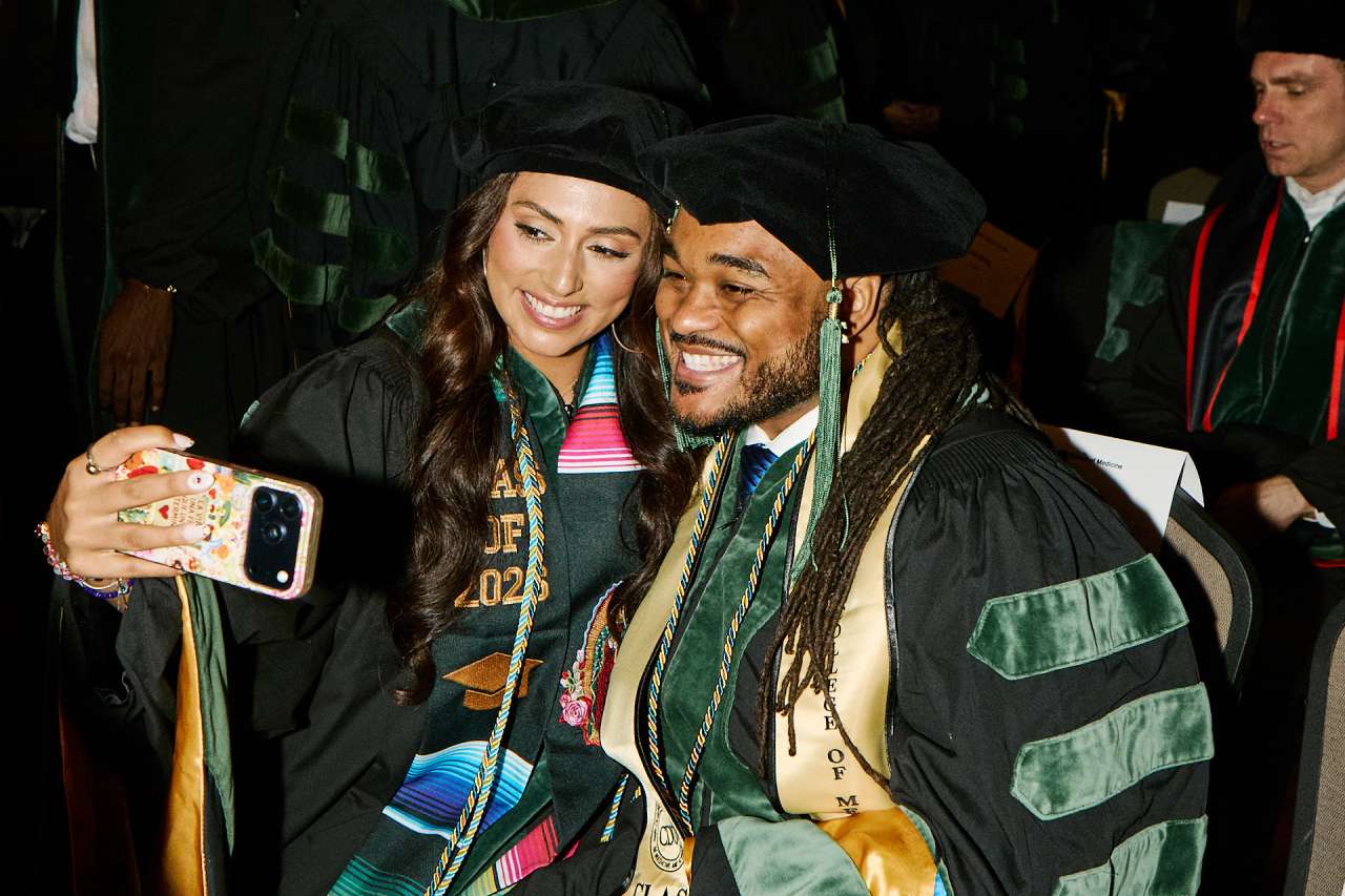 Two graduating UCLA doctors take a selfie together before the graduation ceremony.