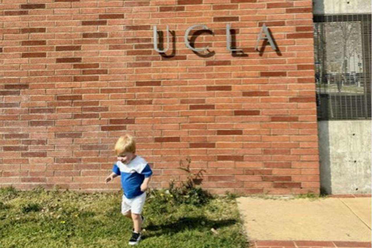 Levi Jonathan walks in the grass outside of a UCLA building