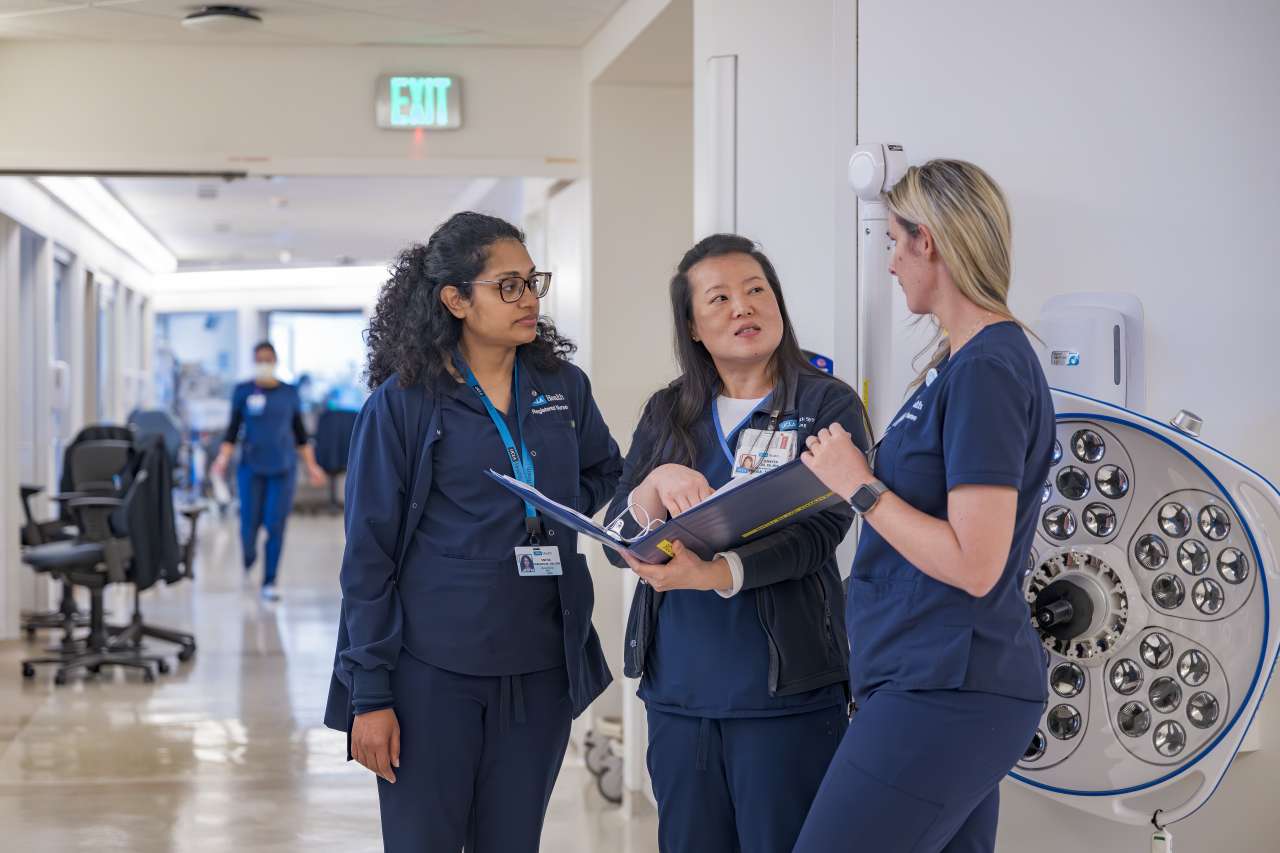 Unit director Jennifer Do engages with nurses in the Transplant/Surgical ICU to review vital information for patient care.
