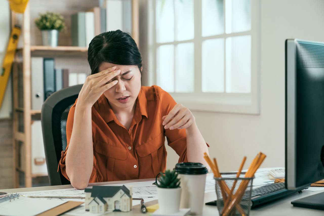 Woman with a headache working at a computer
