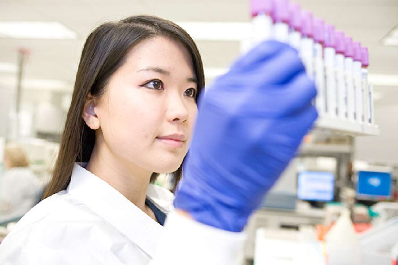 Researcher looking at test tubes