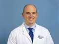 Headshot of Dr. Brian Shuch in white coat and blue tie
