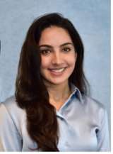 Head-and-shoulders of person with face obscured, long dark hair, light blue blouse.