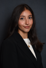 Headshot of Marie Voskanyan, who has brown hair and is wearing a black blazer and white shirt.