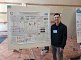 Nicholas Bayley stands in front of his display at Neurology Science Day 2024