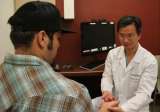 Dr. Daniel Lu checking patient's hand