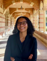Headshot of Kennady, who is wearing black frame glasses and a black blazer.