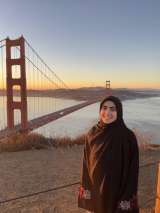 Howra Alammarah posing in front of a bridge during sunset