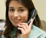 Woman talking on a telephone in an office setting.
