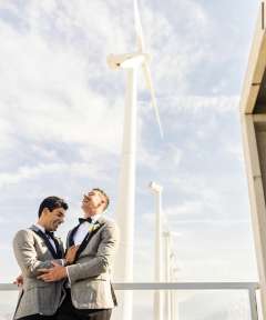 DAPM Dr. Dane Saksa and husband, Ryan, in front of windmills