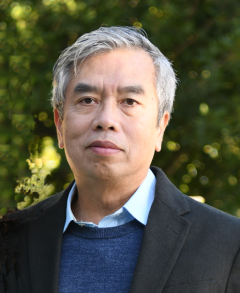 headshot of Hung Ton-That, PhD in an outdoor setting with leaves in the backgrounds
