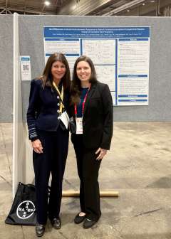 Katherine Hampilos and her mentor posing in front of Katherine's research poster.