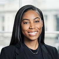 Headshot of Kiara Mayhand, showcasing long dark hair and a professional attire.