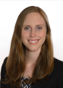 Professional headshot of Anna Zemke with long hair and a dark blazer.