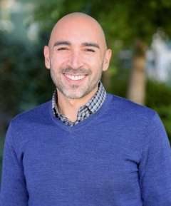 Doctor Marco Hidalgo smiling, wearing a blue sweater