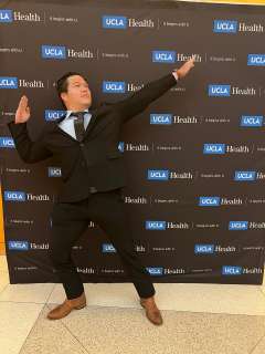 Fellow Physician, Dr. Alex Pham, poses in front of UCLA Health backdrop