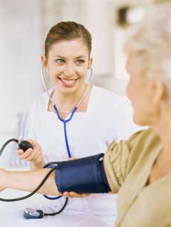 A nurse checking an older woman's pulse