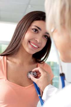 A young woman being examined with a stethoscope