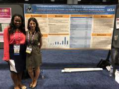 Two fellows in front of poster for Colon Cancer Prevention