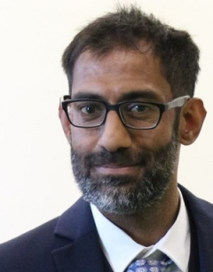headshot of Abdulsamie Patel Postdoctoral Scholar in front of a white background wearing a suit and glasses