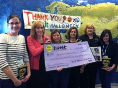 Group of people holding donation check from Spirit Halloween Stores