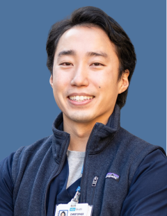 An Asian Male Nurse smiling where his UCLA badge.