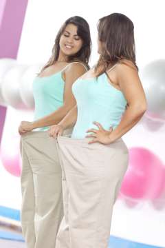 Woman wearing oversized pants looking in the mirror