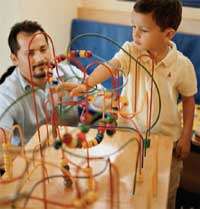 Father and child playing with toy in waiting room