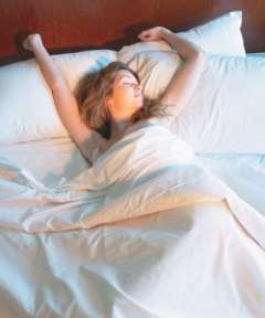 Woman in bed stretching