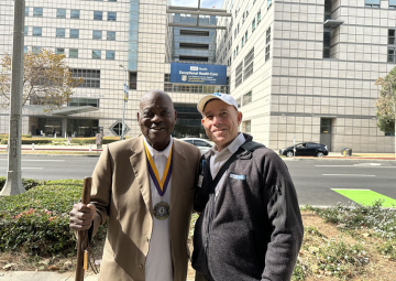 UCLA Urology member and a Bridge Builders Foundation representative hug in front of UCLA Hospital