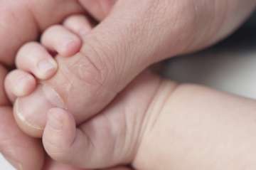 baby hand holding on to thumb