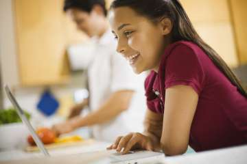 girl smiling while using a laptop