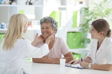 Doctor checking woman's throat