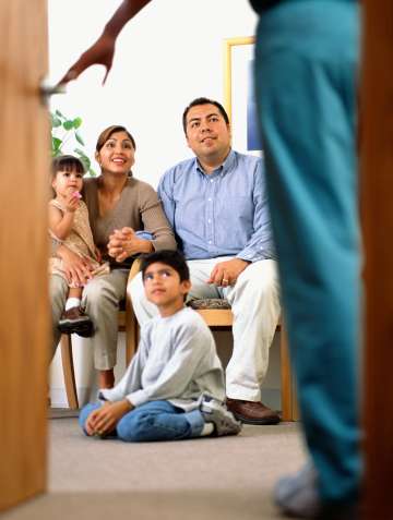 Doctor walking into room with a sitting family