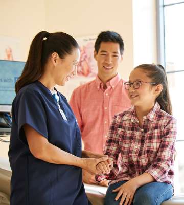 Nurse with young female patient and her father