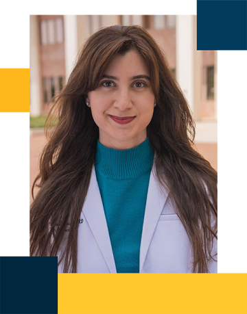 Dr. Tina Mosaferi wearing a white lab coat and a teal turtleneck outside of switzer plaza.