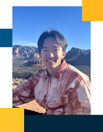 Qicong Sheng wearing a red button down in the outdoors with mountains in the background