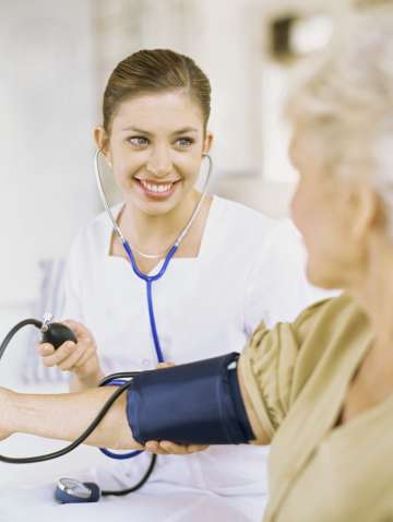 Nurse taking elderly woman's blood pressure