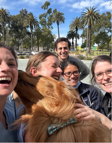 a group of Internal Medicine Residents with a dog liking ones face