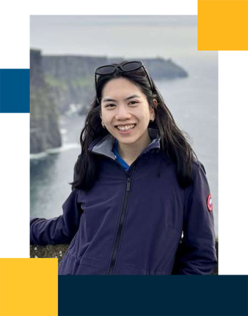 Emma Zeng wearing a jacket outdoors with a cliff and the ocean behind her