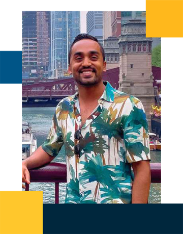 Jay Shah wearing a tropical shirt with a city river and buildings in the backgrounds